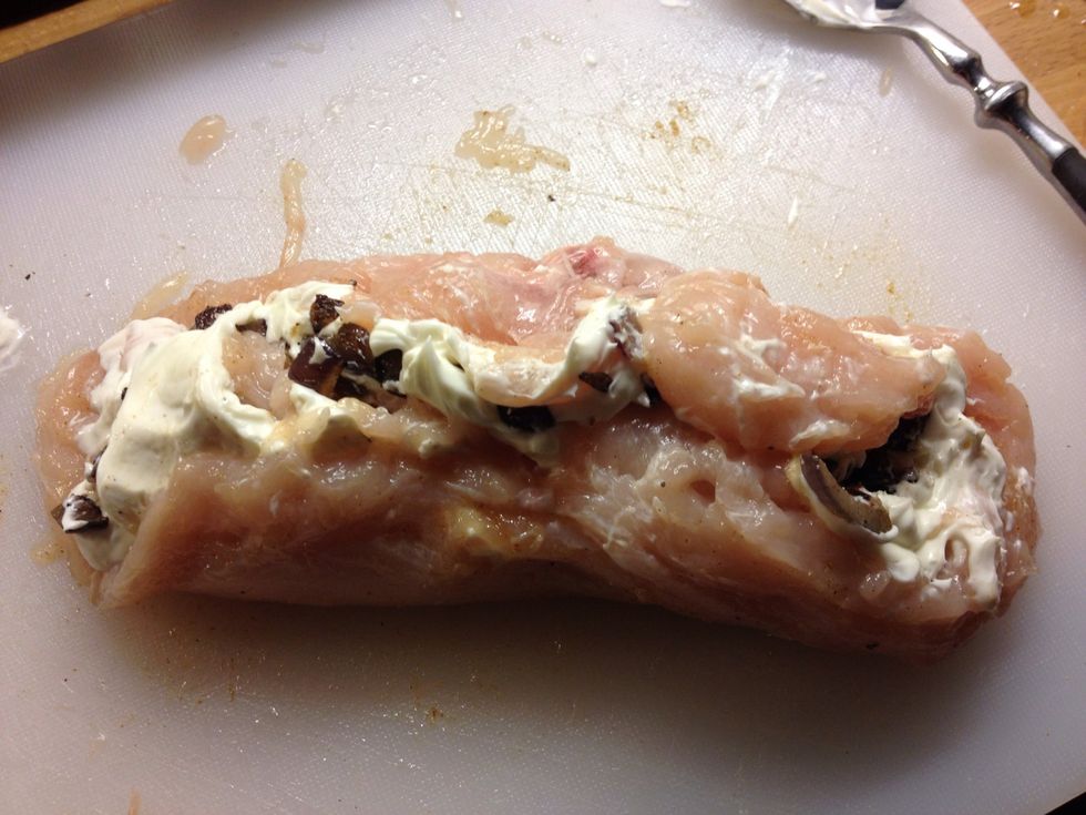 Now roll up the breast by starting from one side. The cheese will act like a glue you will be surprised at how easy this is :).