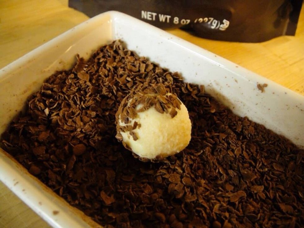 Now scoop balls of the ganache with a spoon and roll quickly between your palms. If your hands get sticky dust them with powdered sugar. Roll the truffles in the shaved chocolate/cocoa mixture.