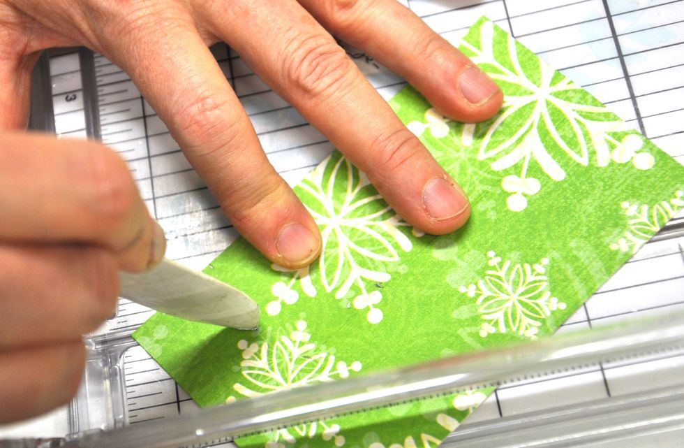 Now score from the bottom left corner and the bottom right corner to the three inch point on the middle fold line.