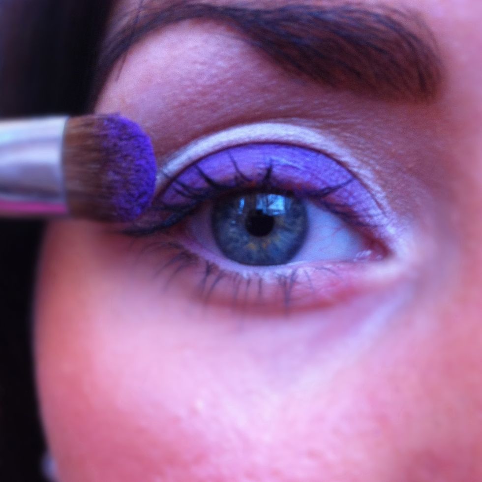 Now set the cream eyeliners.Start applying a lilac matte eye shadow to the centre of the eye lids with an oval brush.Then with an angled brush apply a matte pink eyeshadow to the crease of the eye.