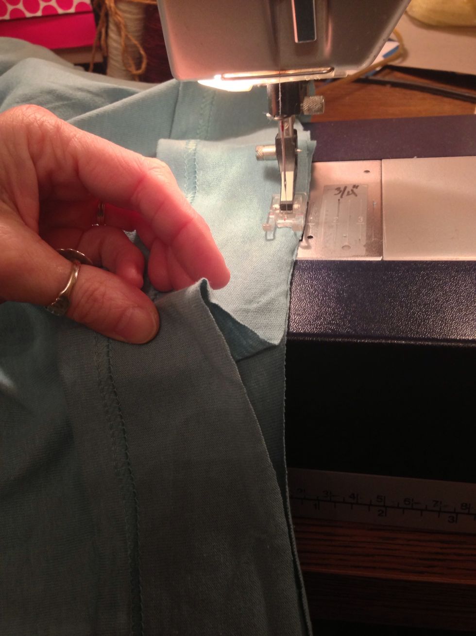 Now sew the original hem back on! Start on one side. Keep the hem strip taught as you go around with a stretch straight stitch. You want them to feed evenly, but the curves will want to stretch out.