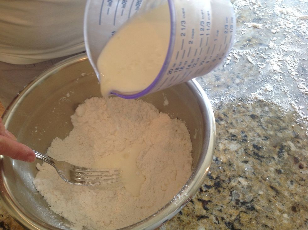Now, slowly, pour about HALF of your buttermilk into the mixture. Use a fork to scrape stuff away from side of bowl and mix together. You can add more milk, but just a little at a time.
