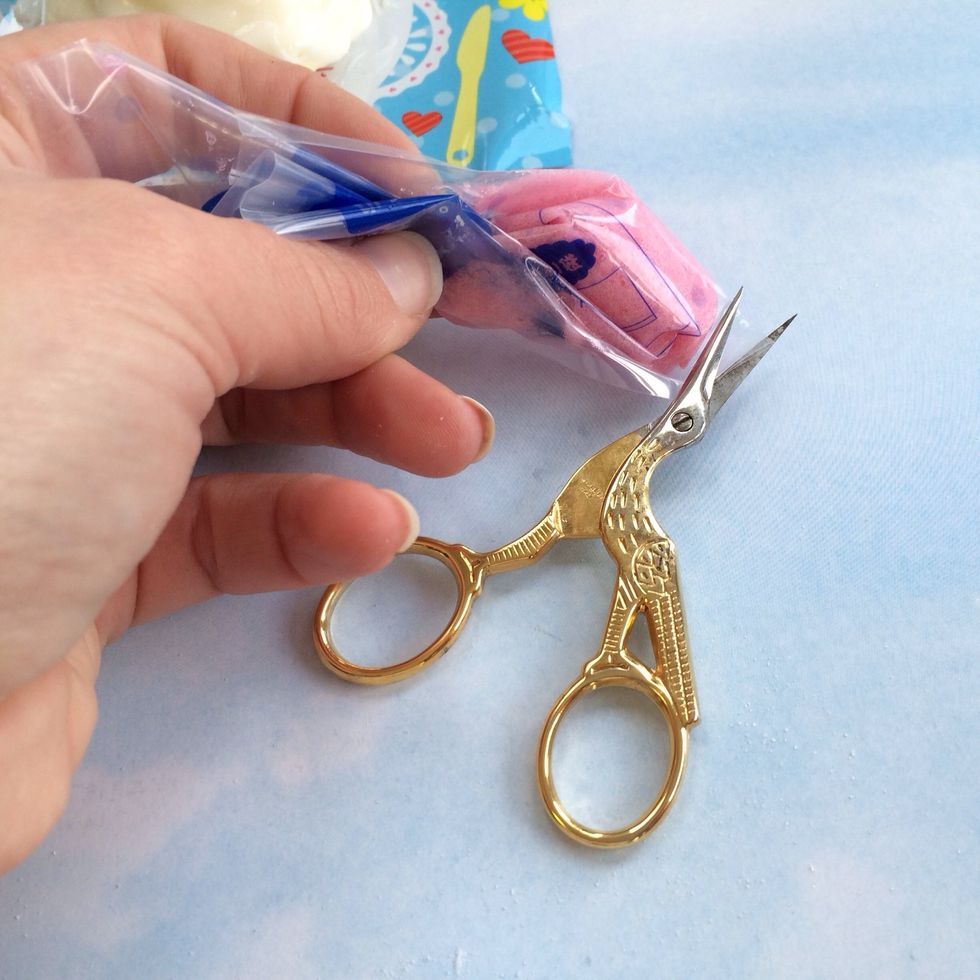 Now Snip a Tiny Tiny end off of the Plastic Pastry Bag. Make sure it's very small, if you cut it too big you won't be able to decorate cake properly with Pink Frosting. You want to have thin line.