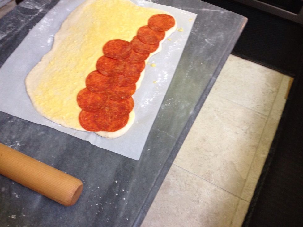 Now start covering the dough with pepperoni slices starting away from the edge you left clean
