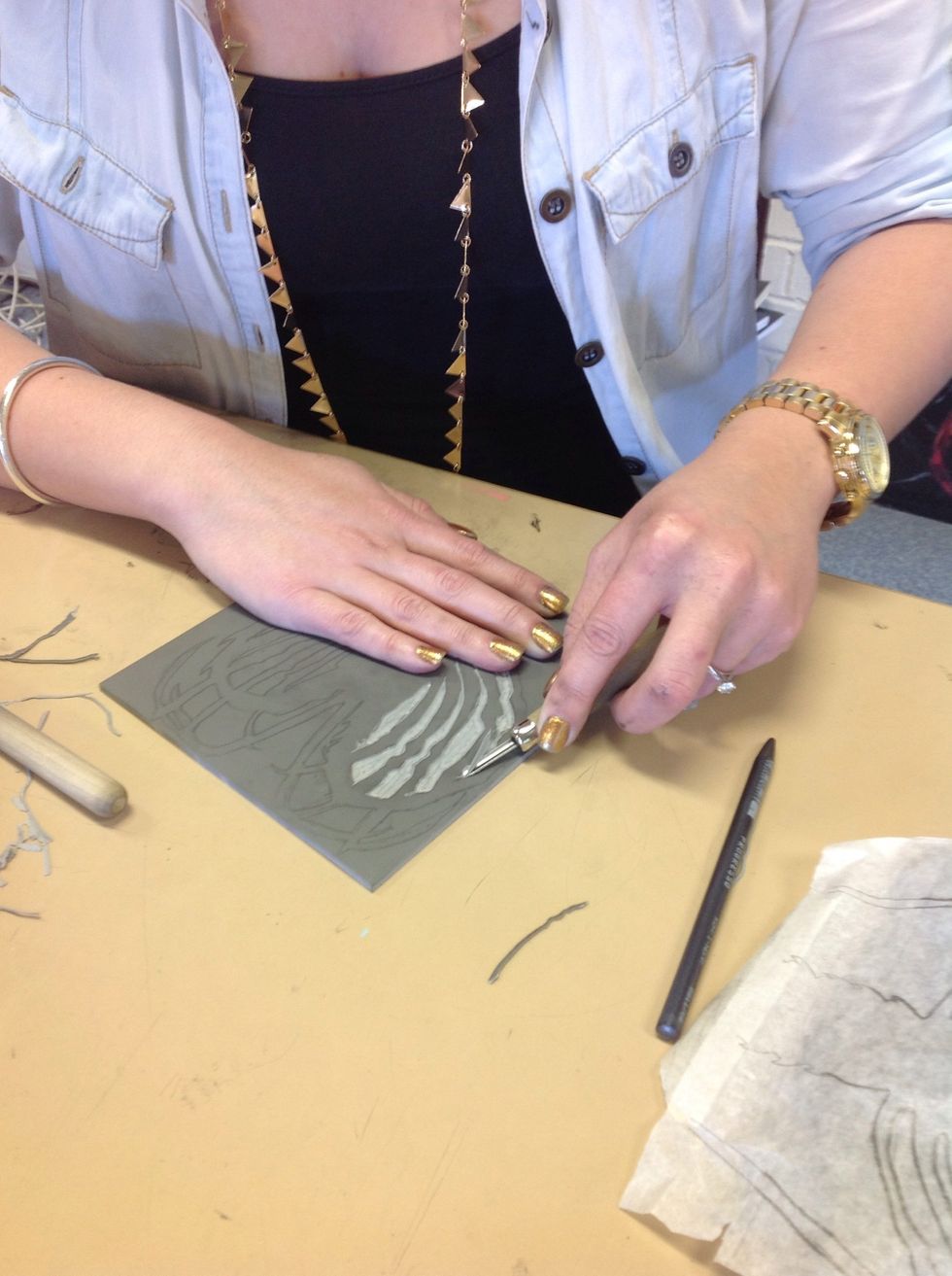 Now start cutting with the Lino cutting tools, always keeping your hand behind the cutting tool! Remember before you start cutting that what you cut will not print and what you leave will print.