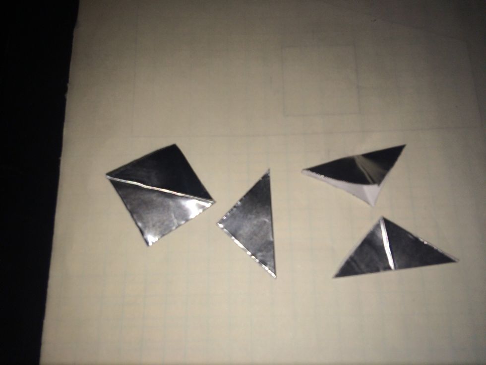 Now start making the wings of the rocket. Start by folding 1 square in half corner to corner. And then open it back up. Now fold the opposite corners together.