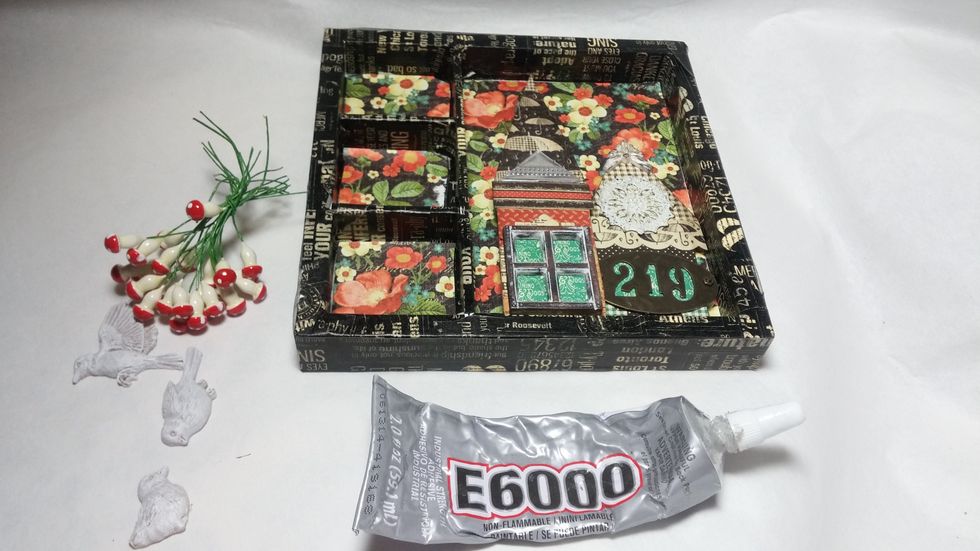 Now start to play with your focal pieces. I discovered that only two of my houses would fit inside at this point. Use a heavy duty glue like E6000 to adhere the elements.