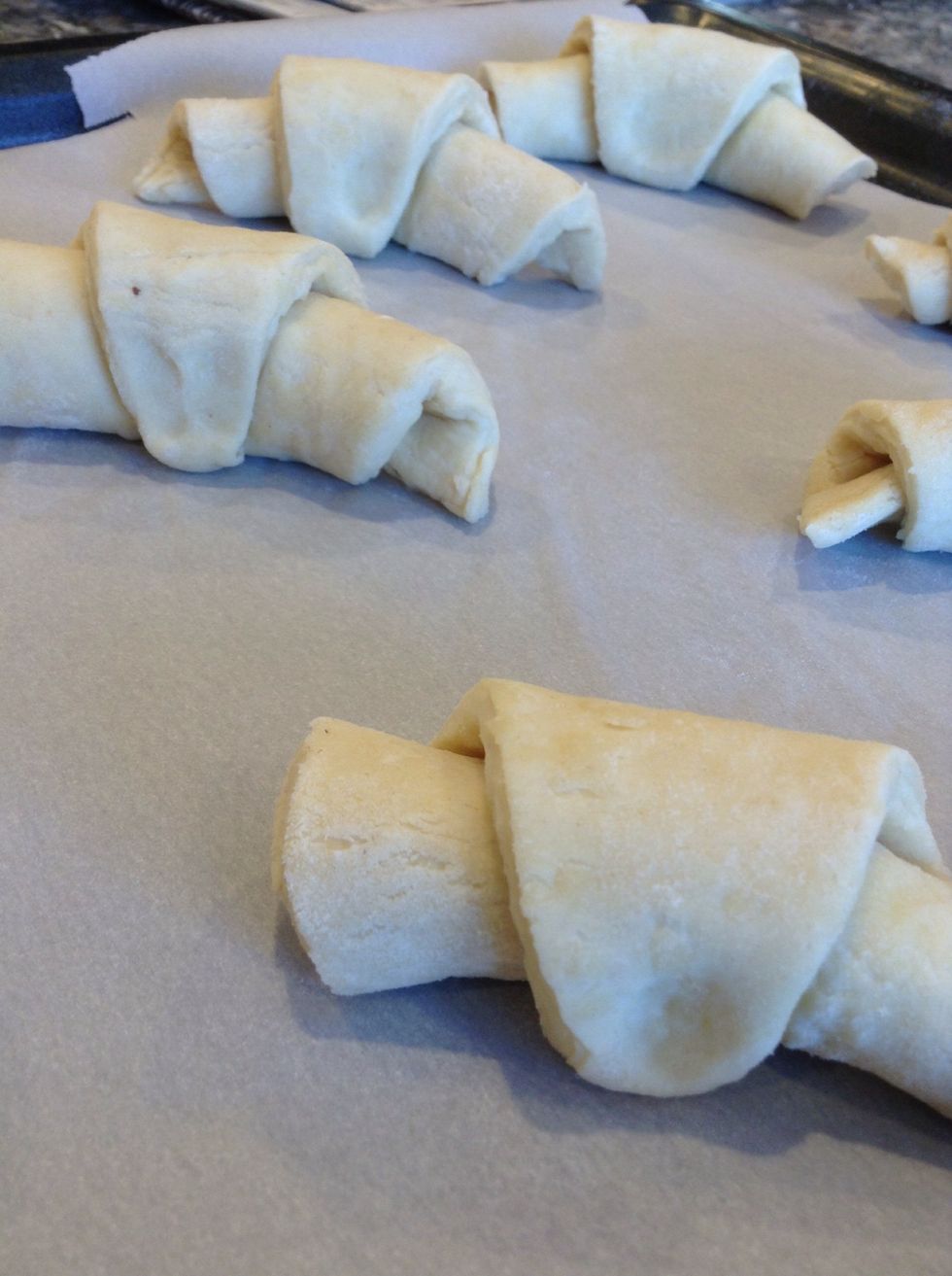 Now starting from the base up, roll the triangle. Once done, put on the baking sheet and proof the dough for 1 hour I. A warm room.