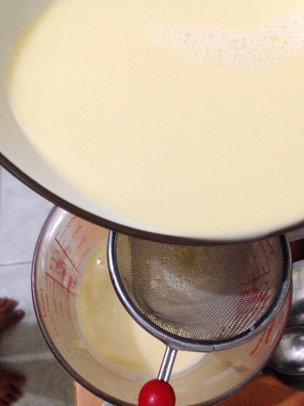 Now strain your egg-milk mixture to a measuring glass or a container that will make your work easier when pouring the mixture into ramekin. Remove any foam on the surface with a spoon