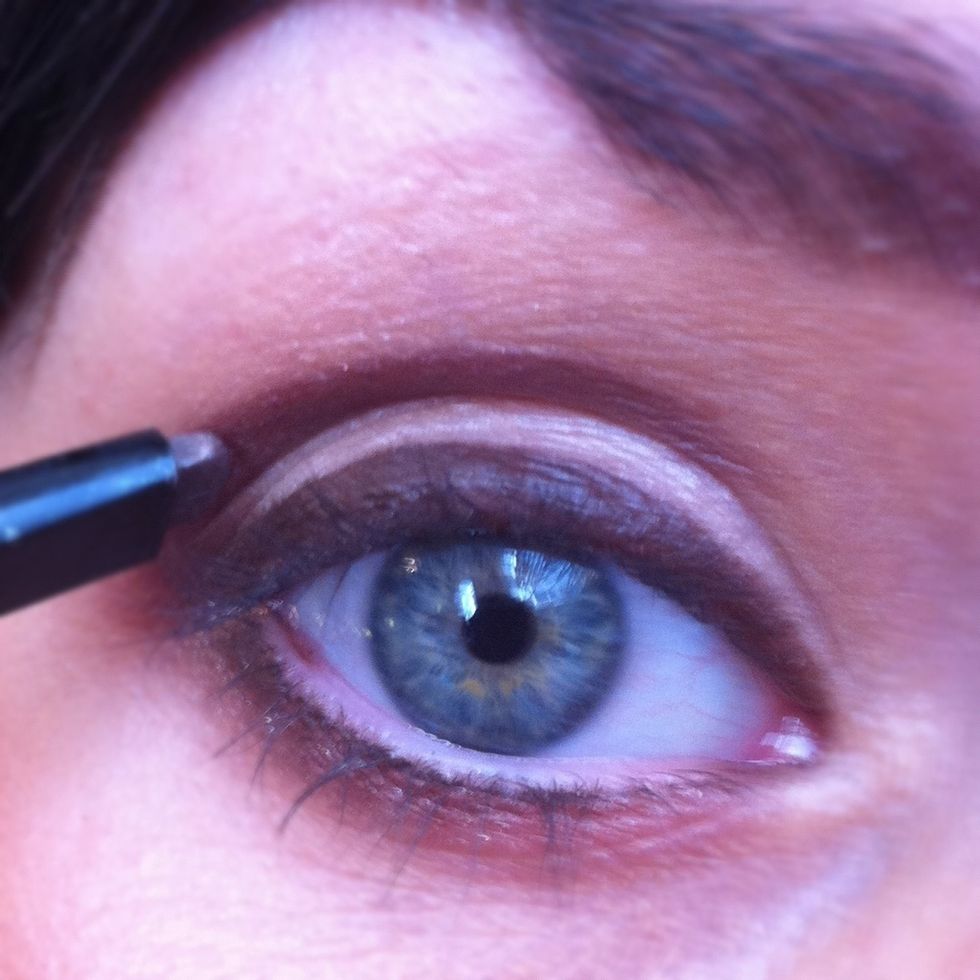 Now take a brown eyeliner pencil and apply the pencil into the crease of the eye for definition.