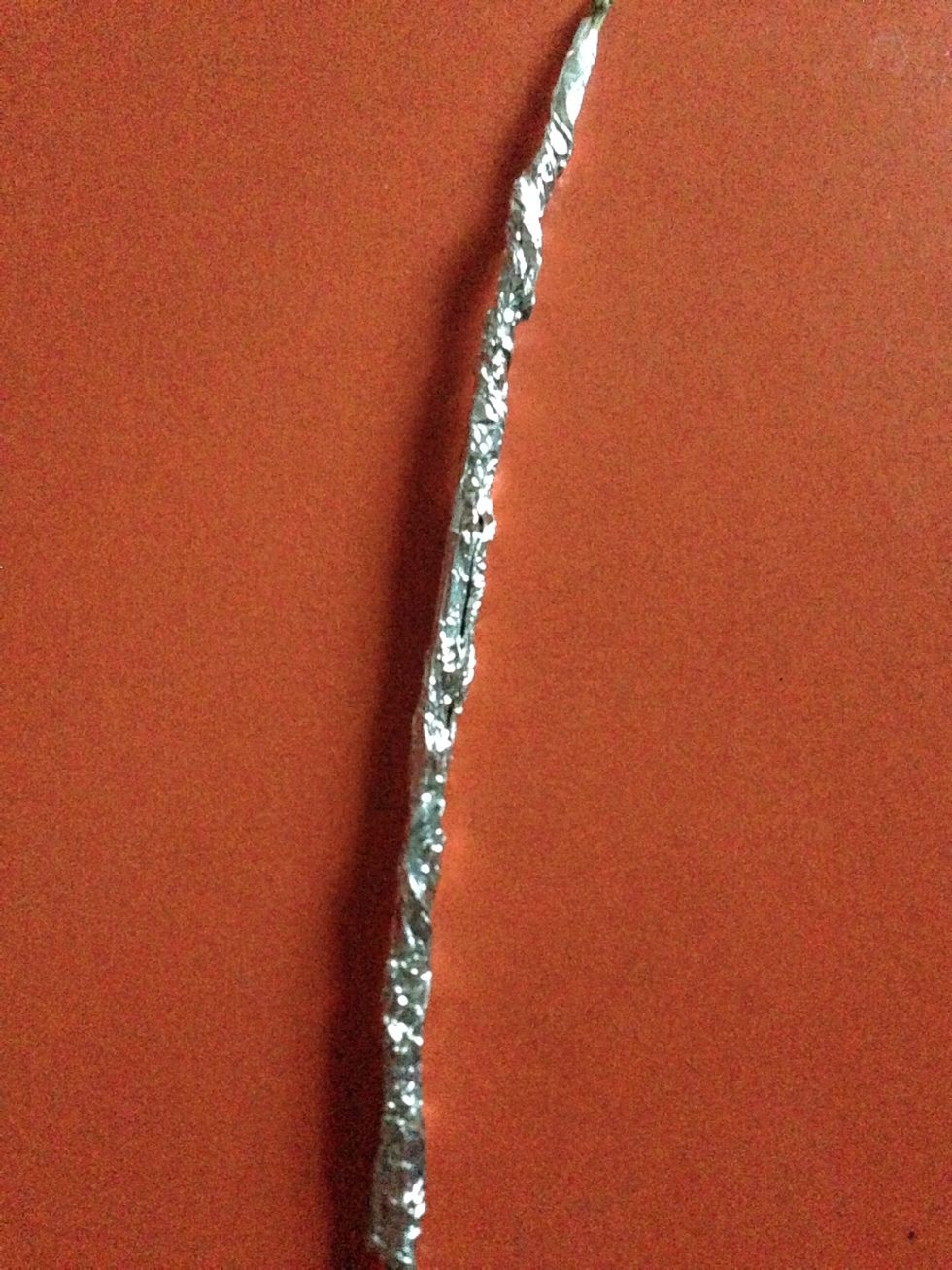 Now , take a garden stick . Roll the foil paper around it like shown in the picture