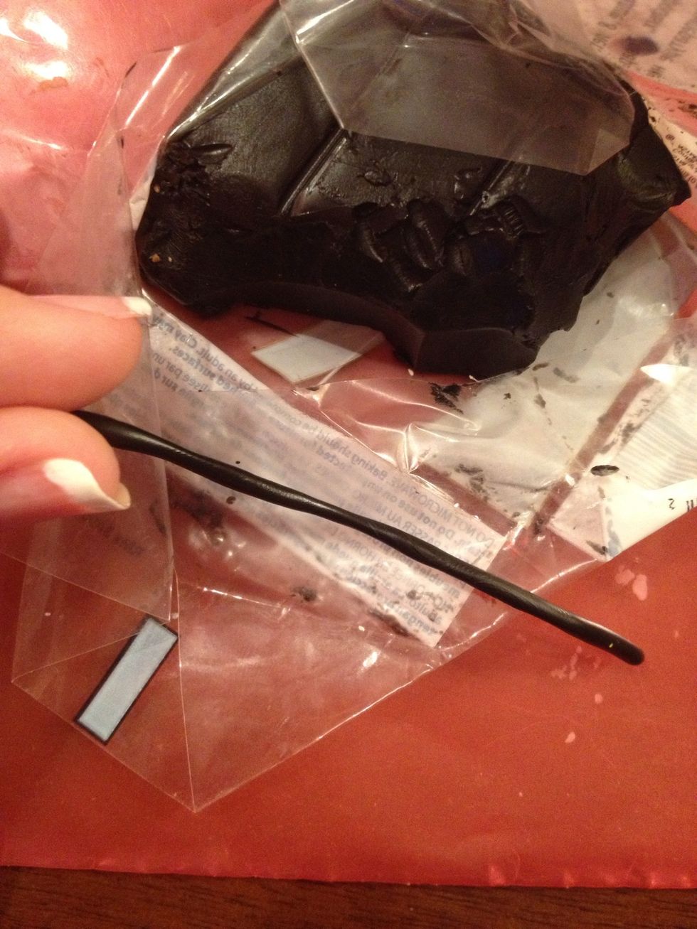 Now take a piece of black clay again and roll it.