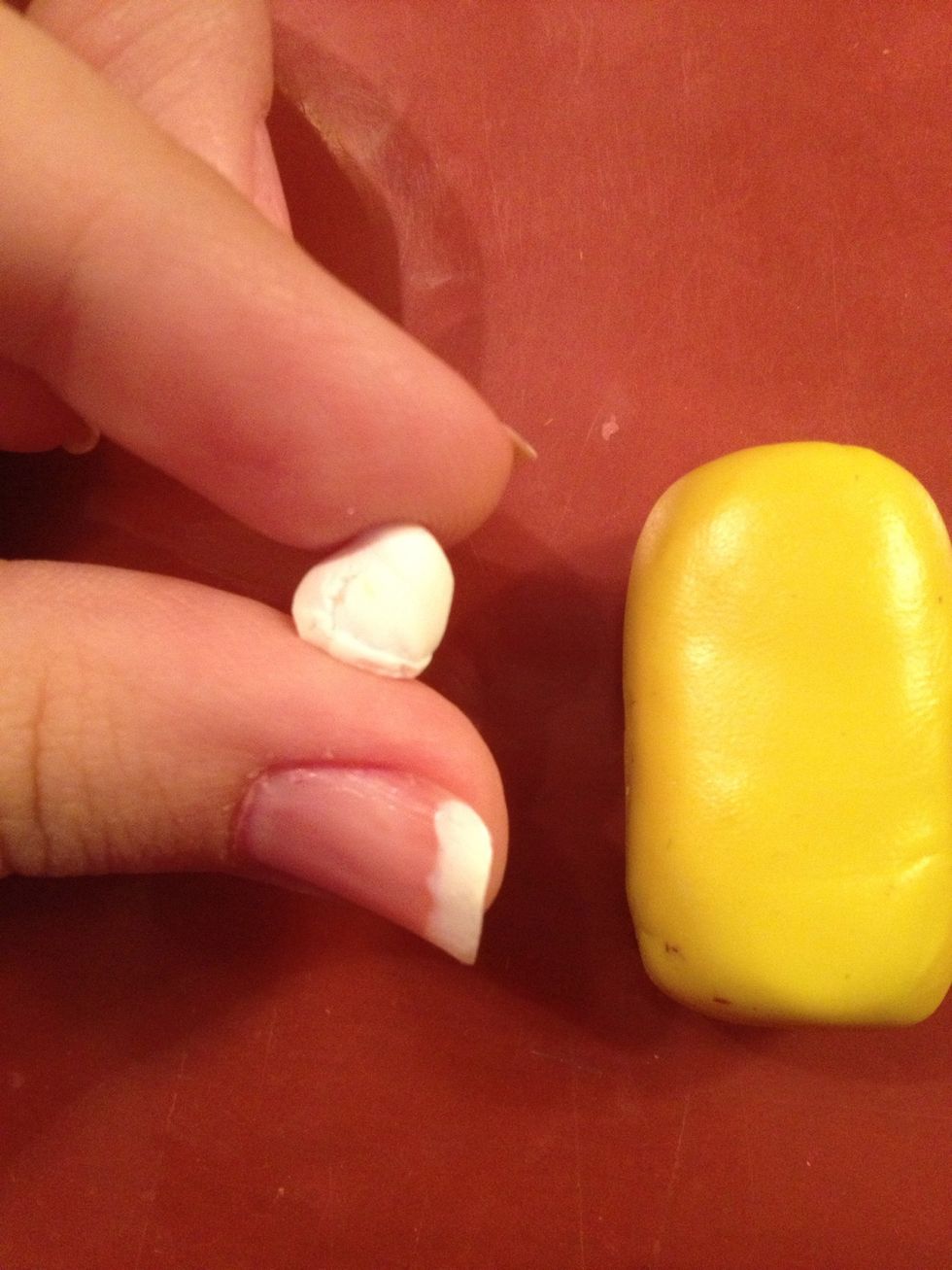 Now take a piece of white clay and make a kind of round tablet.