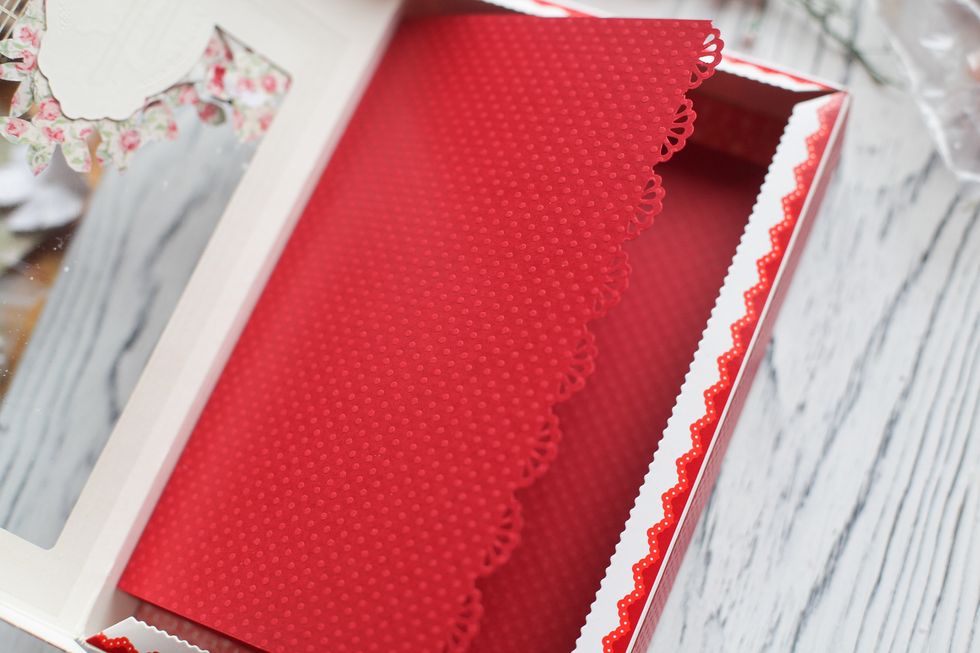 Now take a sheet of red cardstock which lenght is equal to the lenth of the box and width is 2 times bigger. Bind it in the middle and one more time 1 cm left. Put it inside and adhere to the bottom.