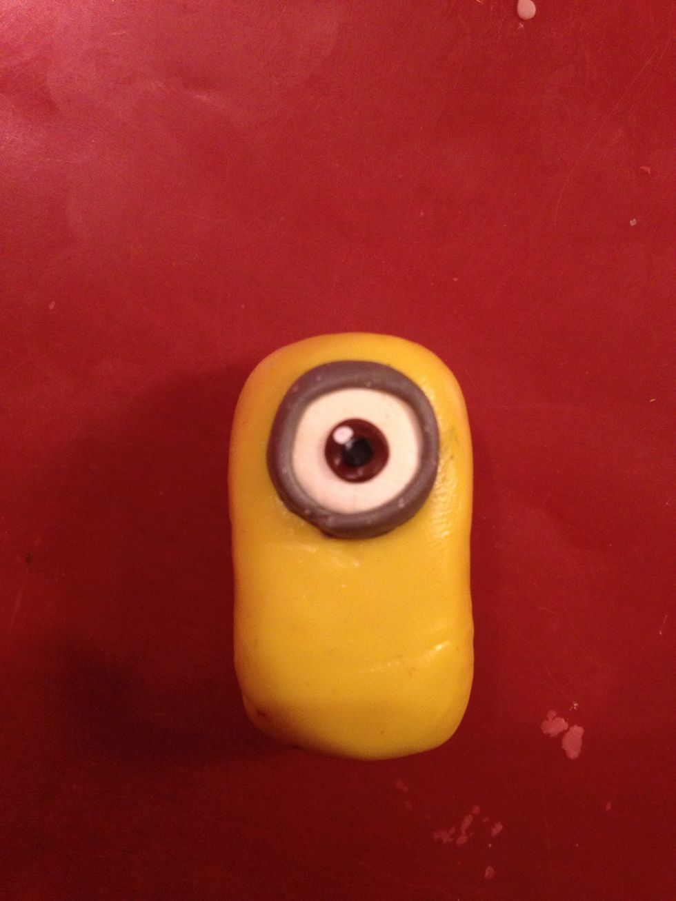 Now take a tiny piece of black and white. Make an apple of the eye and the light reflection.