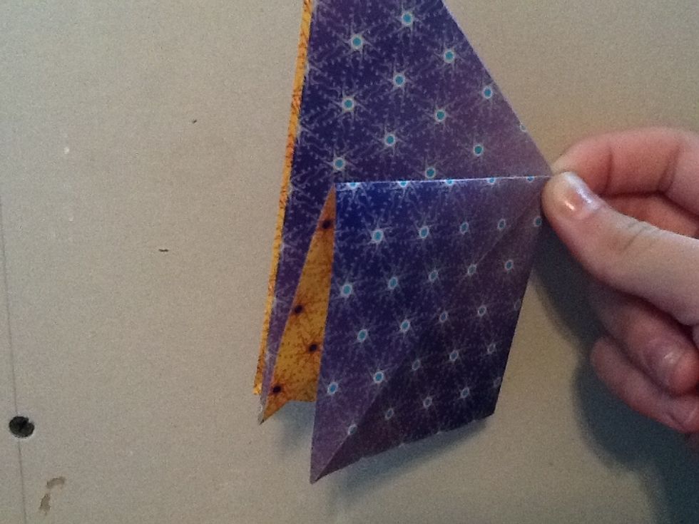 Now take a triangle and press it down to form a square that has a crease in the middle.