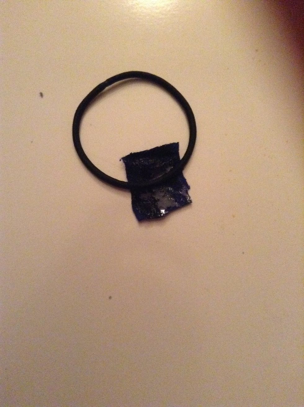 Now take another small piece of fabric, apply glue all over it and attach a nice hair tie or rubber band to the center.