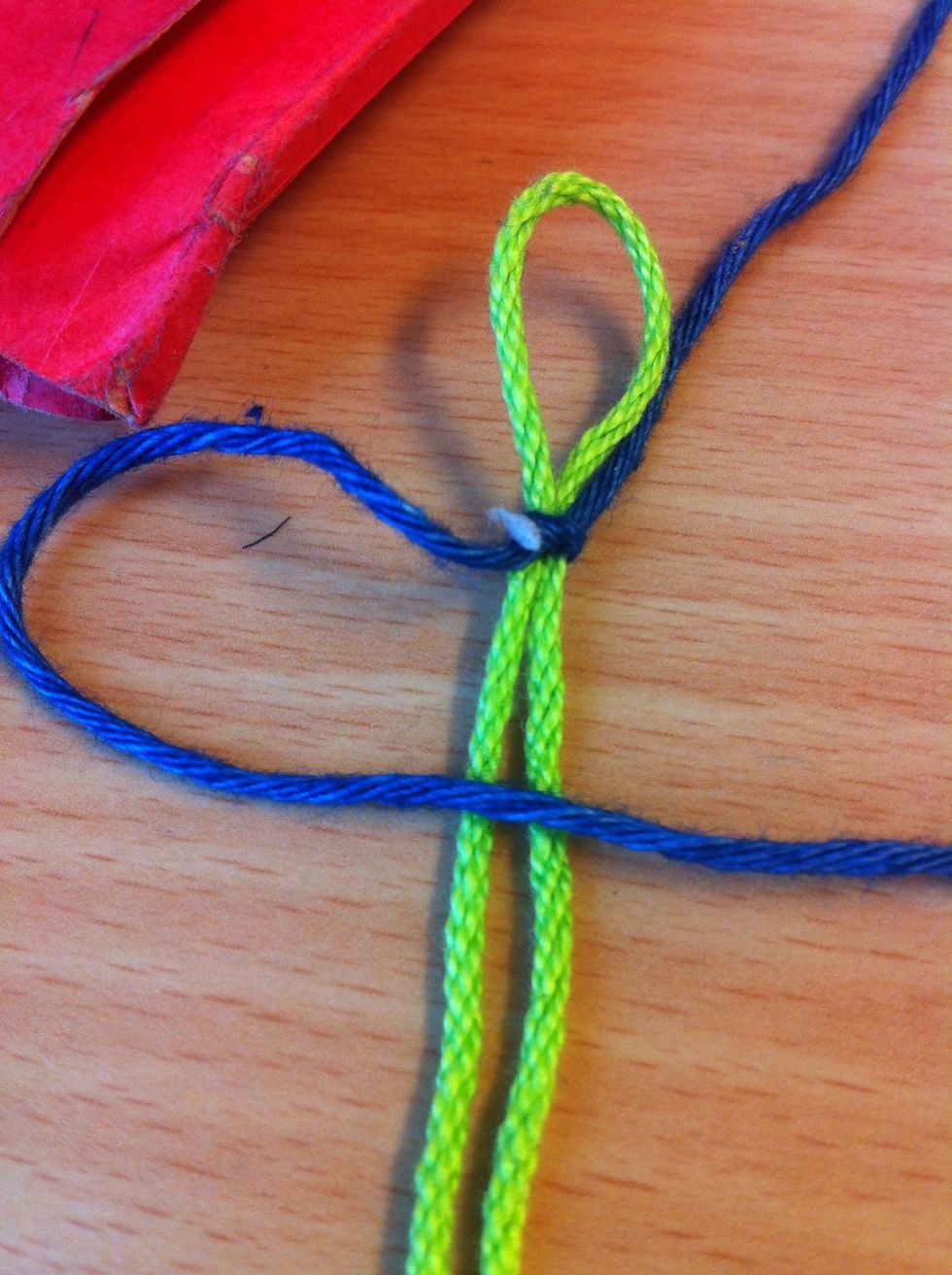 Now take one of the end of the blue tread and lay over the Green ones