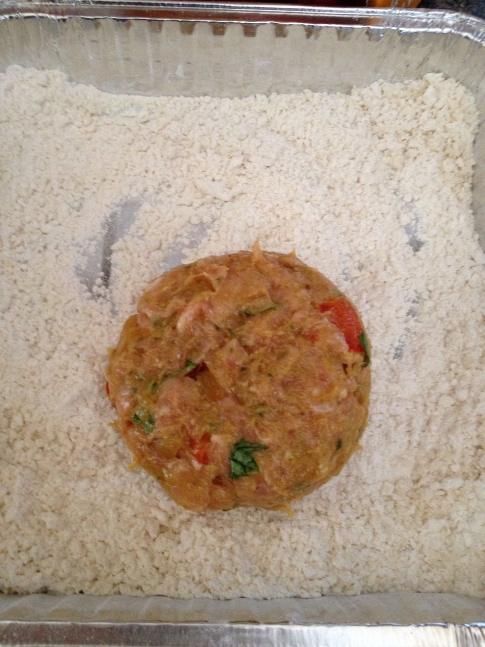 Now take one section in your palm and make a ball, it won't be perfect because minced chicken is way to soft. Drop your ball on the dry mixture and start forming a burger