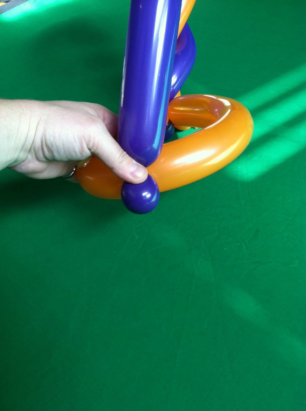 Now take remaining balloon, make a small bubble and attach at the back of the hat