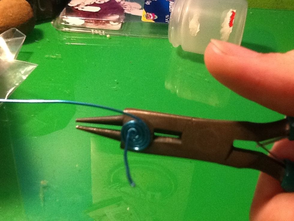 Now take the long wire and make a spiral under the "O" (loop)