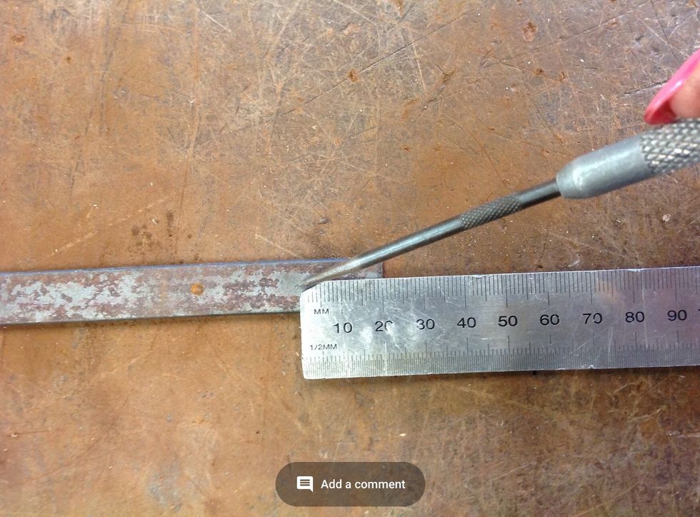 Now take the scroll bit and using a metal ruler and scribe measure 1.5 cm in from the end. Then use a centre punch to make an indent in the centre of the line.