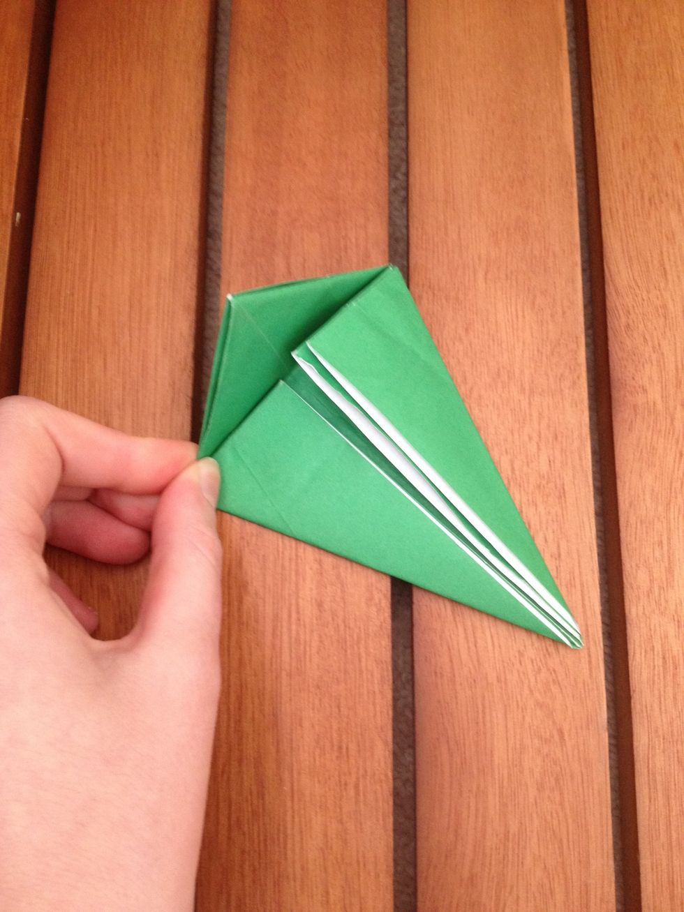 Now take the top, previously the top left corner of the square, and fold on top of both pieces you've just folded.