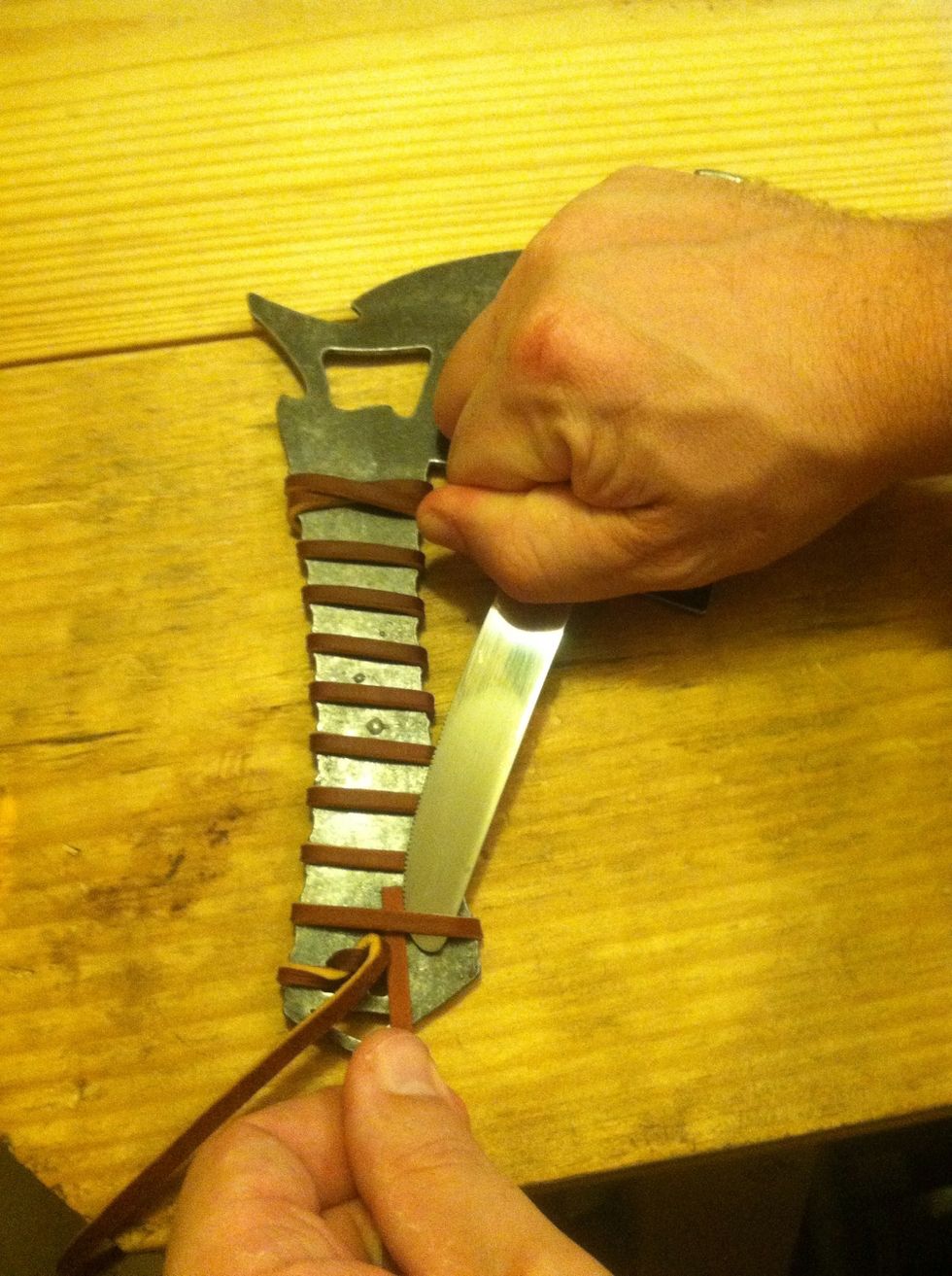 Now take your knife, or similar flat object, and pry up on the strap so we can feed the end under to secure.