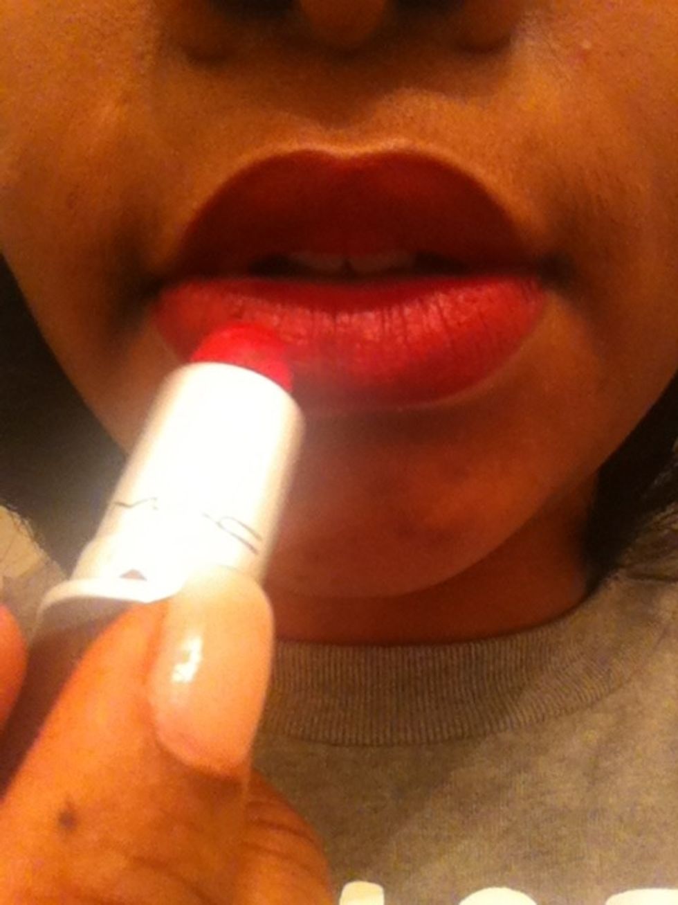 Now take your Ruby Red lipstick and gently smooth it into your lips. Make sure you get any accidental spots outside of your lip line.