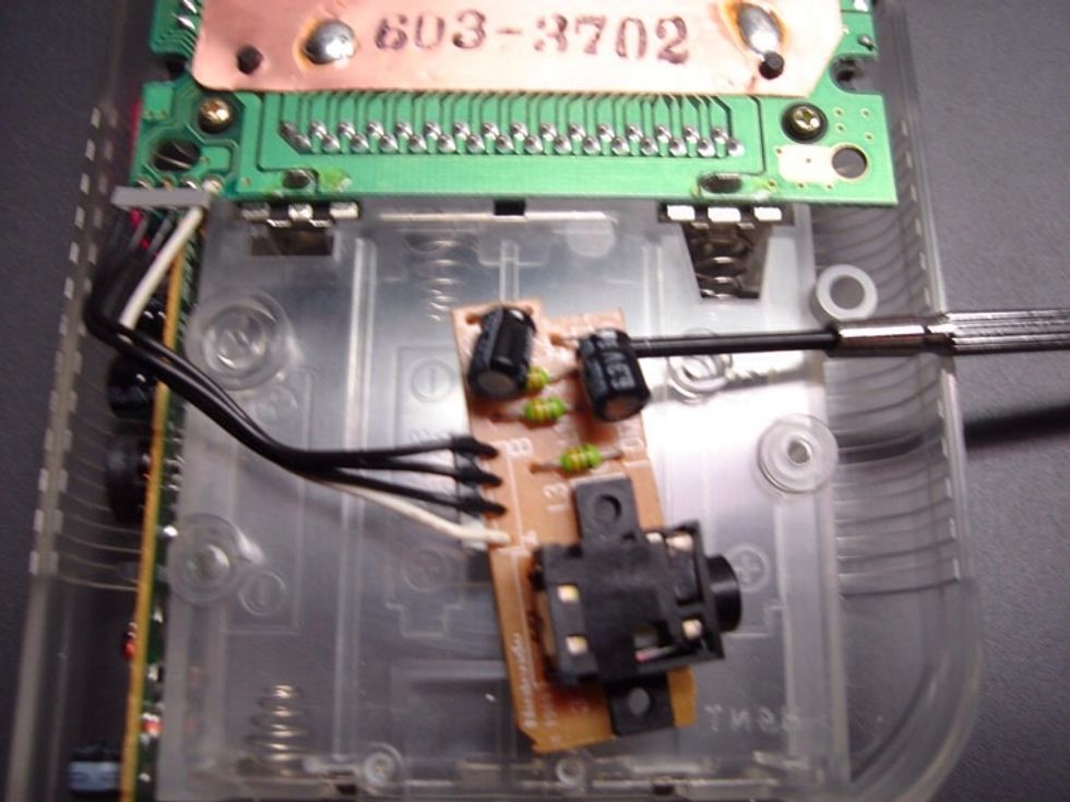 Now take your screw driver and place it between the board and the capacitors. Very carefully bend the leads so the capacitors lay flat against the board as opposed to pointing outwards from it.