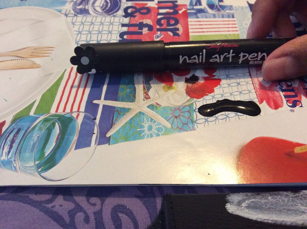 Now taking the nail art pen and black polish. Spill some black polish out in order to use the pen