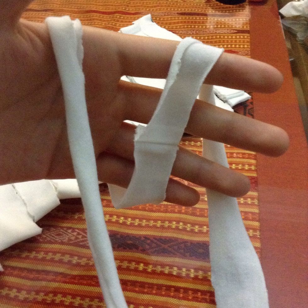 Now taking those stripes, wrap it around your hand 3-4 times. The more times you wrap it, the smaller and tighter your scarf rings will be.