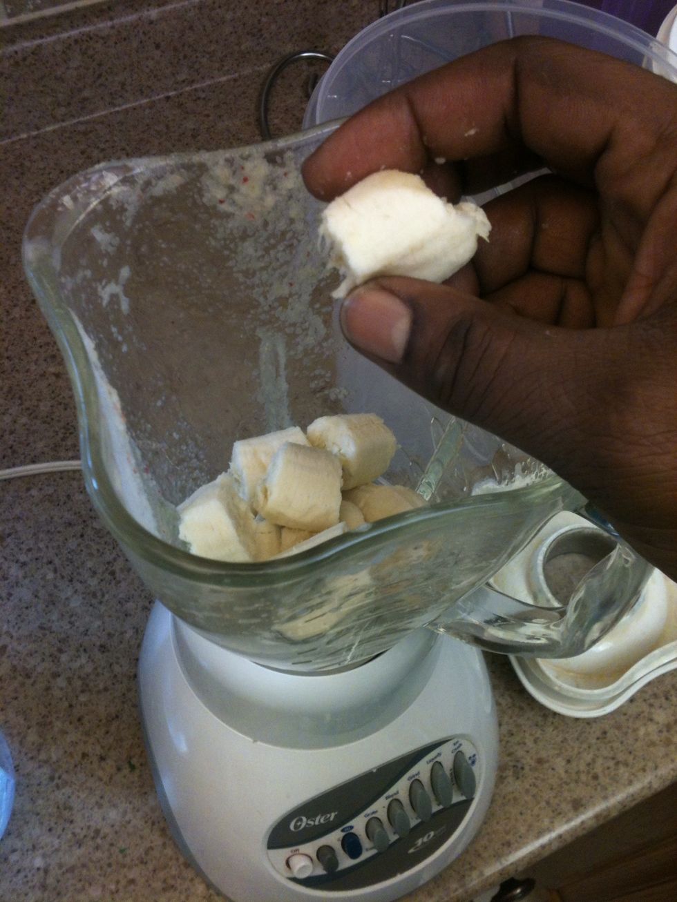 Now that hard stuff is blended, time for the rest! Add your banana broken into smaller parts.