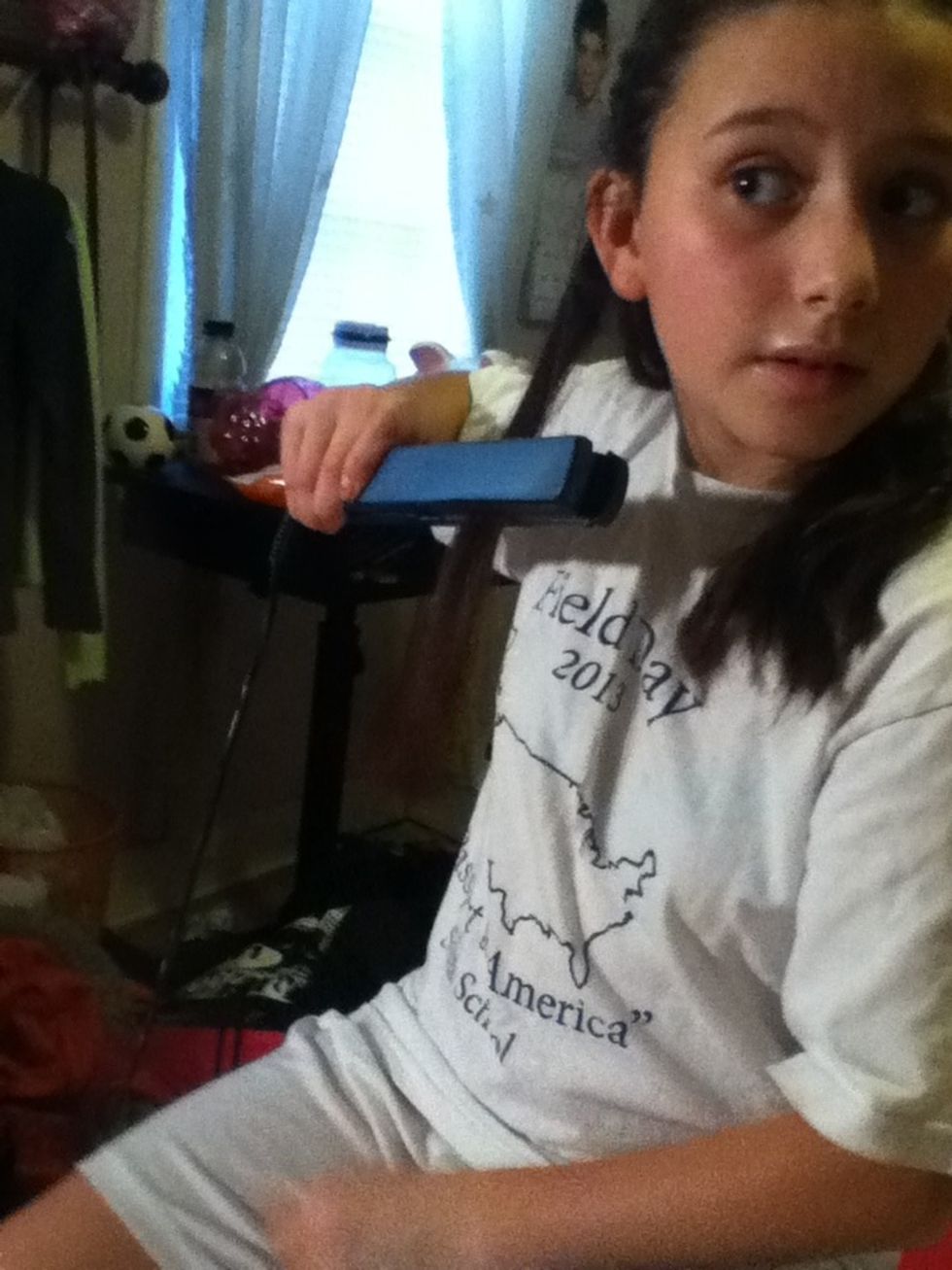 Now that it is clasped turn your straightener up so you have hair under neath it and then slowly drag your straightener down to release