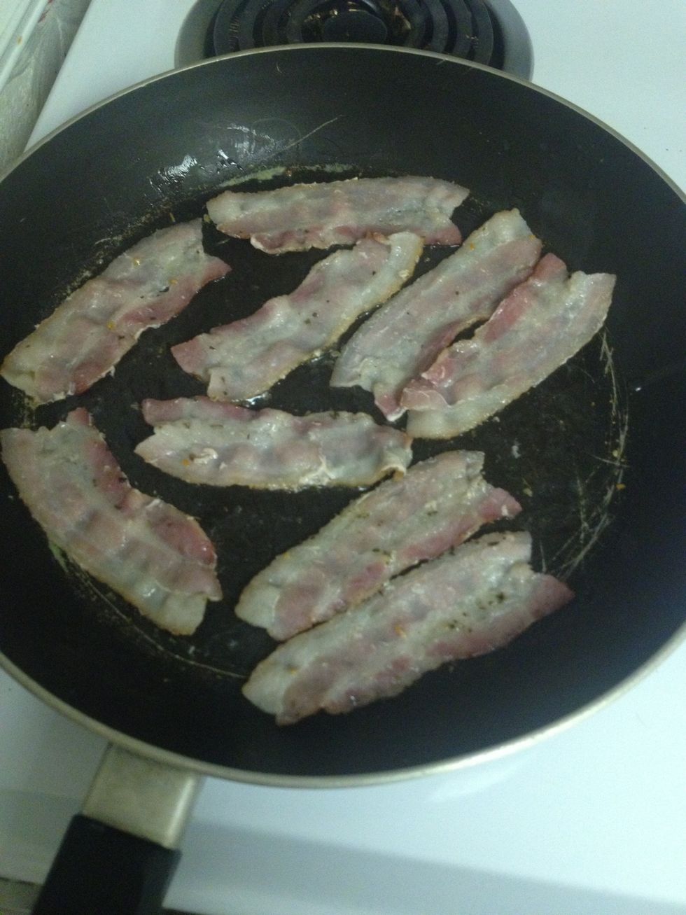 Now that it's cooked for a while, and partially shrunk, I flip them. You don't want to flip bacon too often, just let it cook. I only ever flip it twice. Ps don't season again, one side is enough.