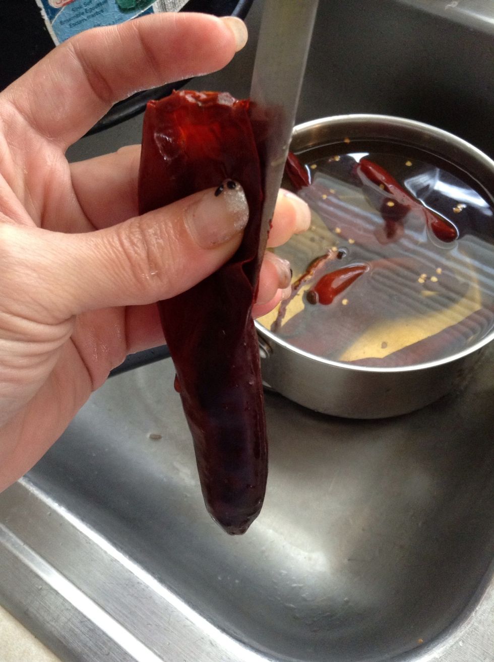 Now that the chiles are cooked...cut them open to take out the seeds.