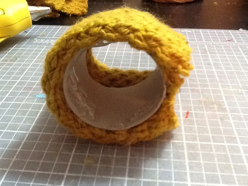 Now that the fabric is glued to the roll, you are going to put a circle of hot glue on each side and press the extra fabric inside the core.