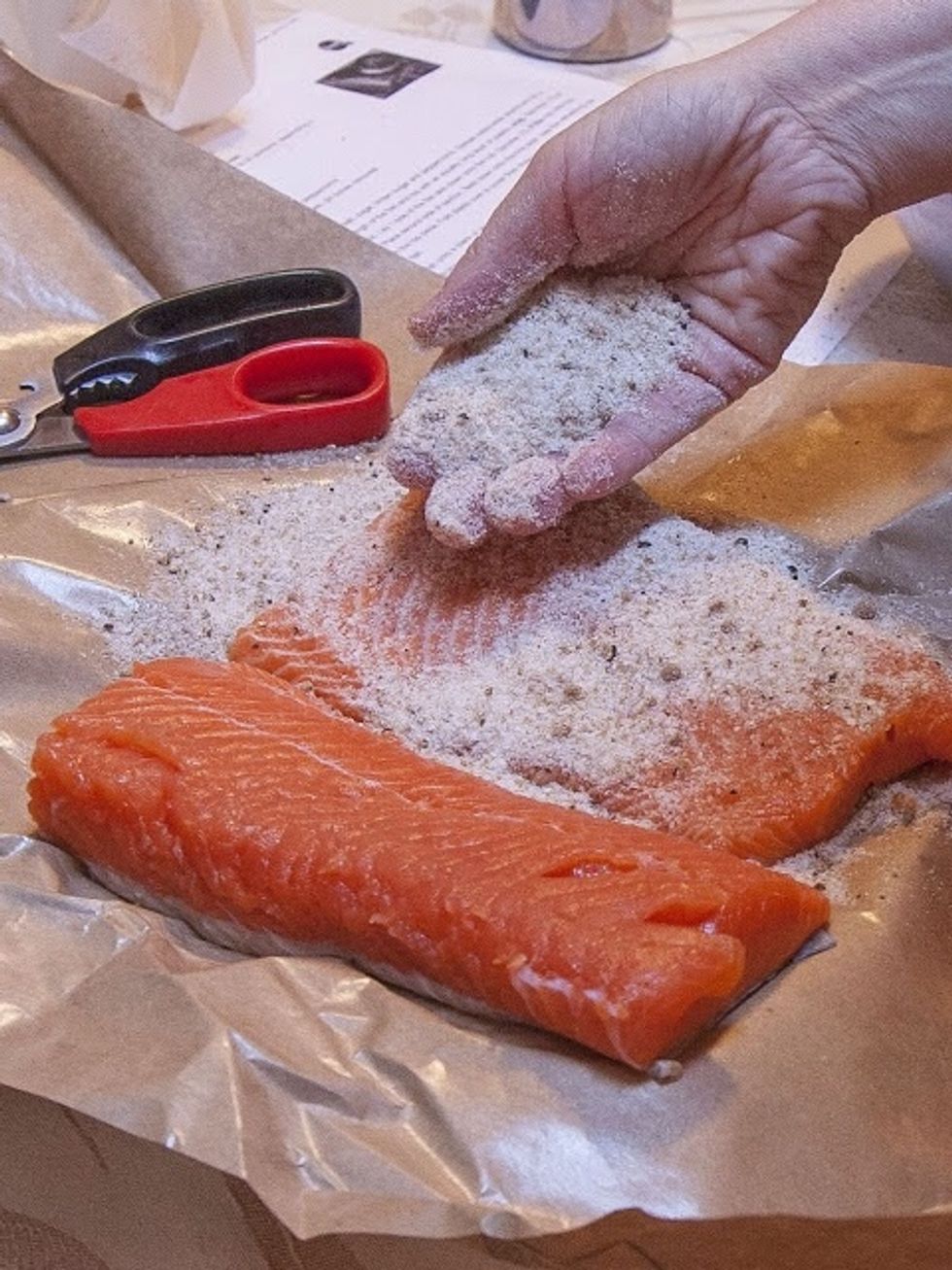 Now that the fish is bone and worm free, sprinkle another 1/3 of the salt sugar pepper mixture onto the flesh side of one side of the salmon. Rub it in well.