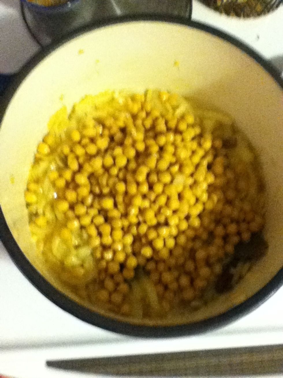 Now that the onions are soft and everything in the pot is beautiful, add the garbanzos and stir fry them for a minute.