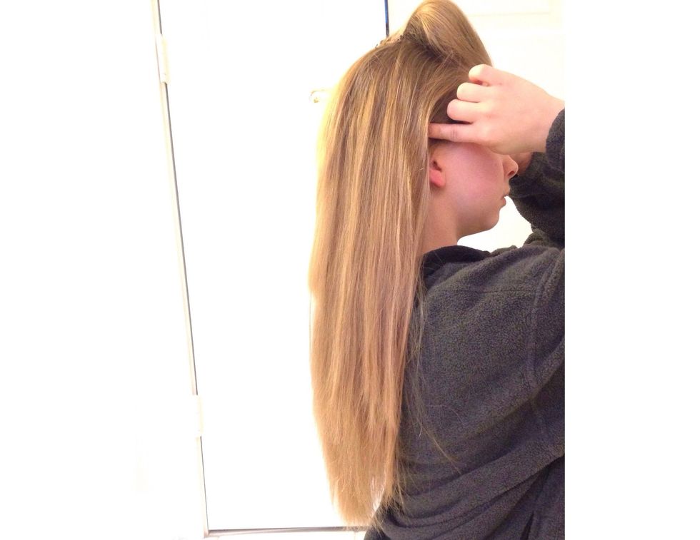 Now that the poof is finished, you can make the ponytail. To make the ponytail,  put your fingers right above your ears and bring them up to the top of your head, gathering hair as you go.