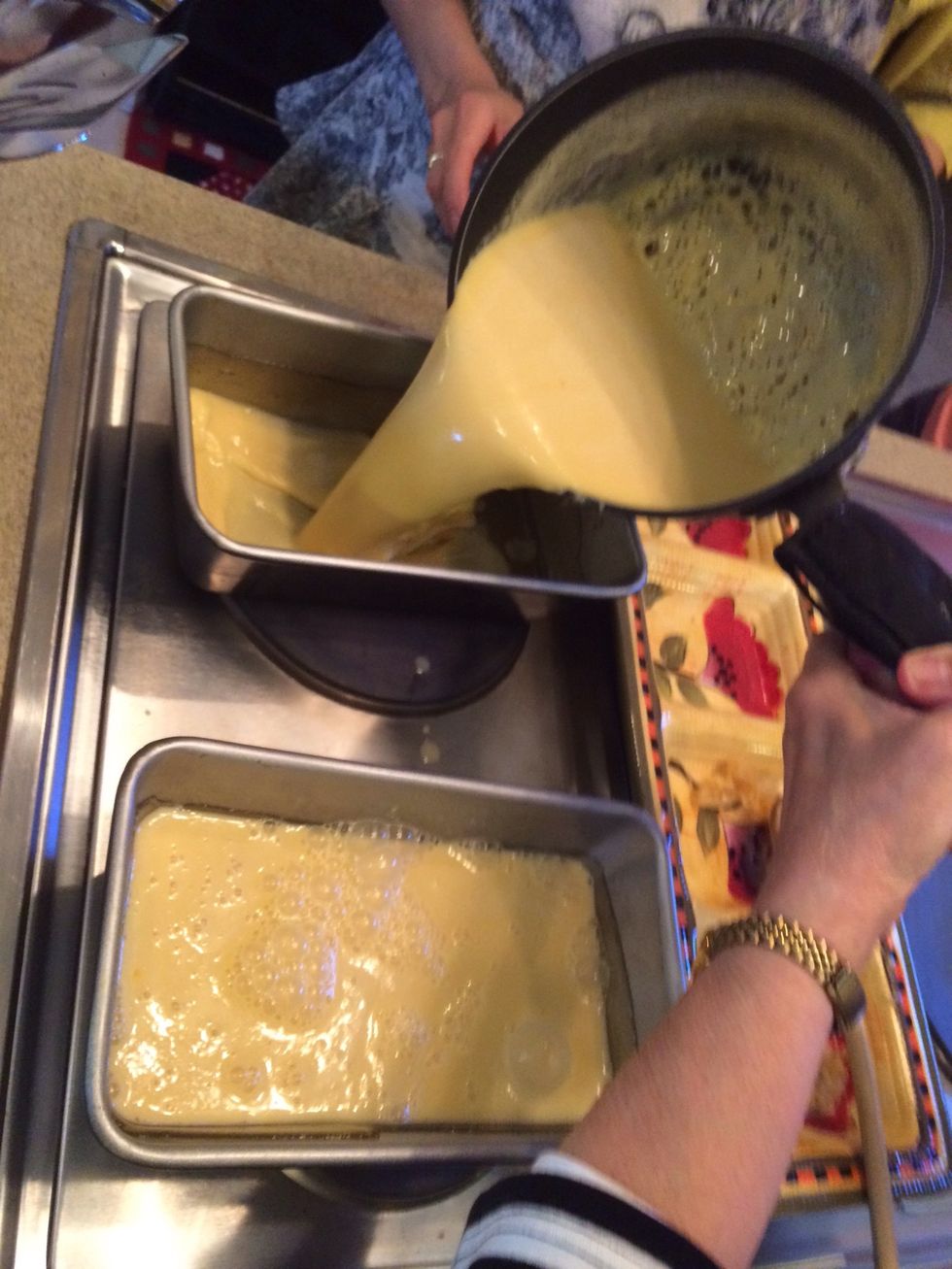 Now that the sugar has hardened and cooled slightly, pour the custard into the bread pans.