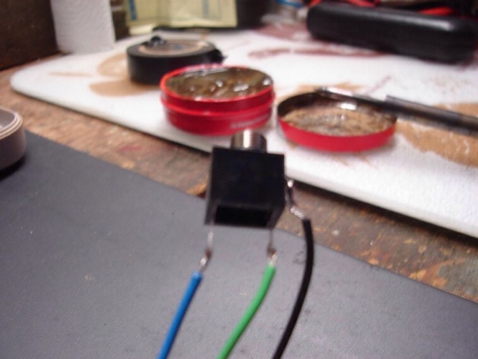 Now that the wires are hooked on the jack, take your screw-driver and flatten the hooks so they don't move as much. Now just take a tiny dab of solder and attach the wires to the jack.