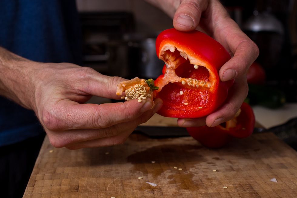 Now that we are done with the teary eyed part, we will move on to the peppers. I've found the best way to deal with peppers is to cut them in half and then pinch the stem out of it.