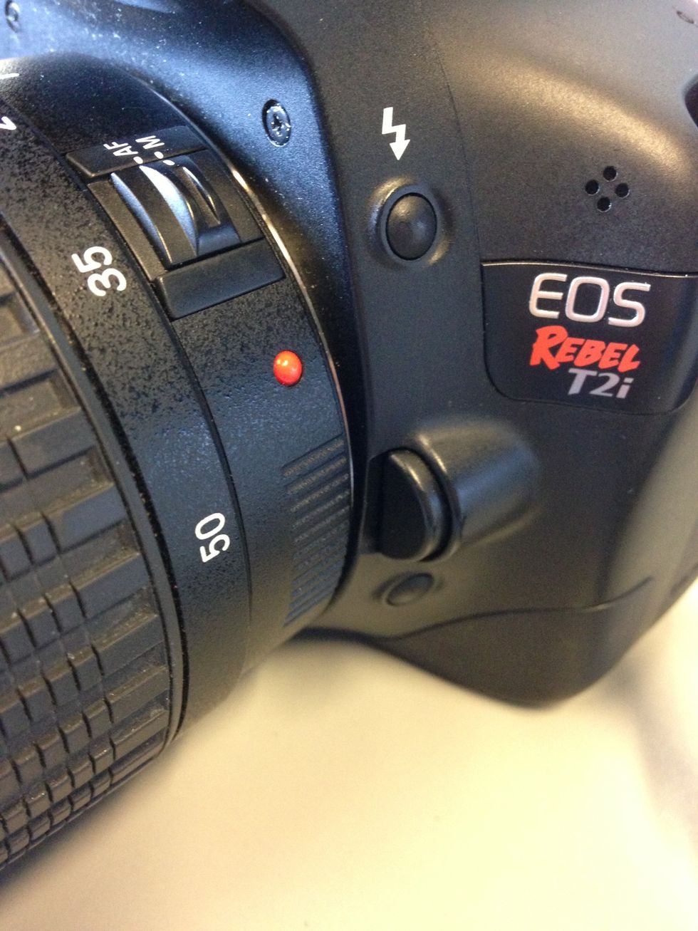 Now that you have chosen a lens, remove your current DSLR lens by pushing down on the half circle button and turning the lens counterclockwise. Then gently remove the lens from the camera.