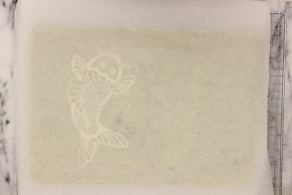 Now that your cake is completely cool. Place a sheet of parchment paper over the cake.