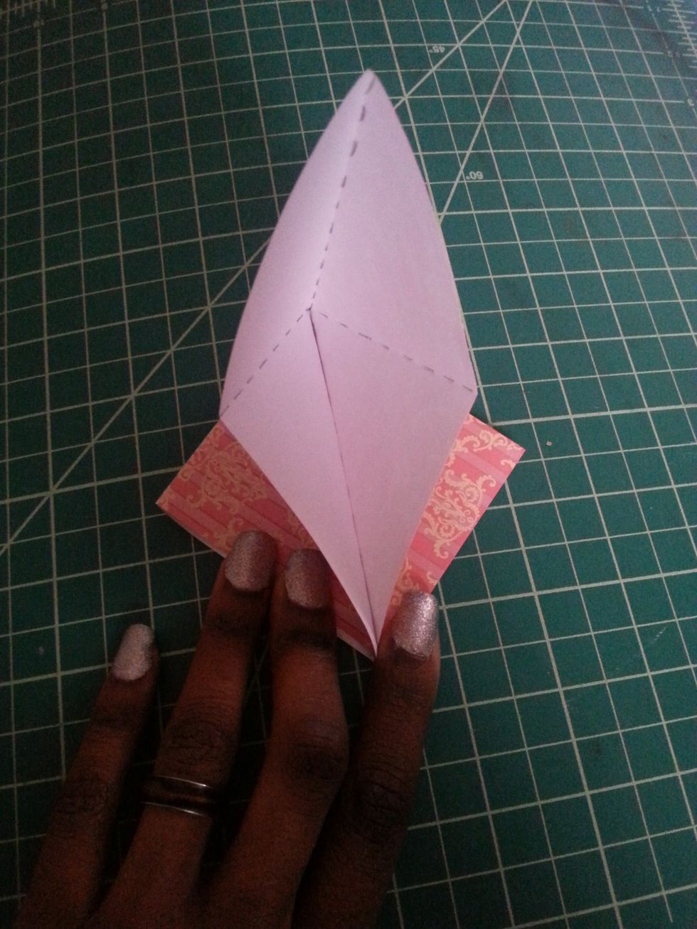 Now that your shape looks like mine on the left, you are going to take the flap that is still open and flatten it down to look like the picture in the next step. This is a modified squash fold.