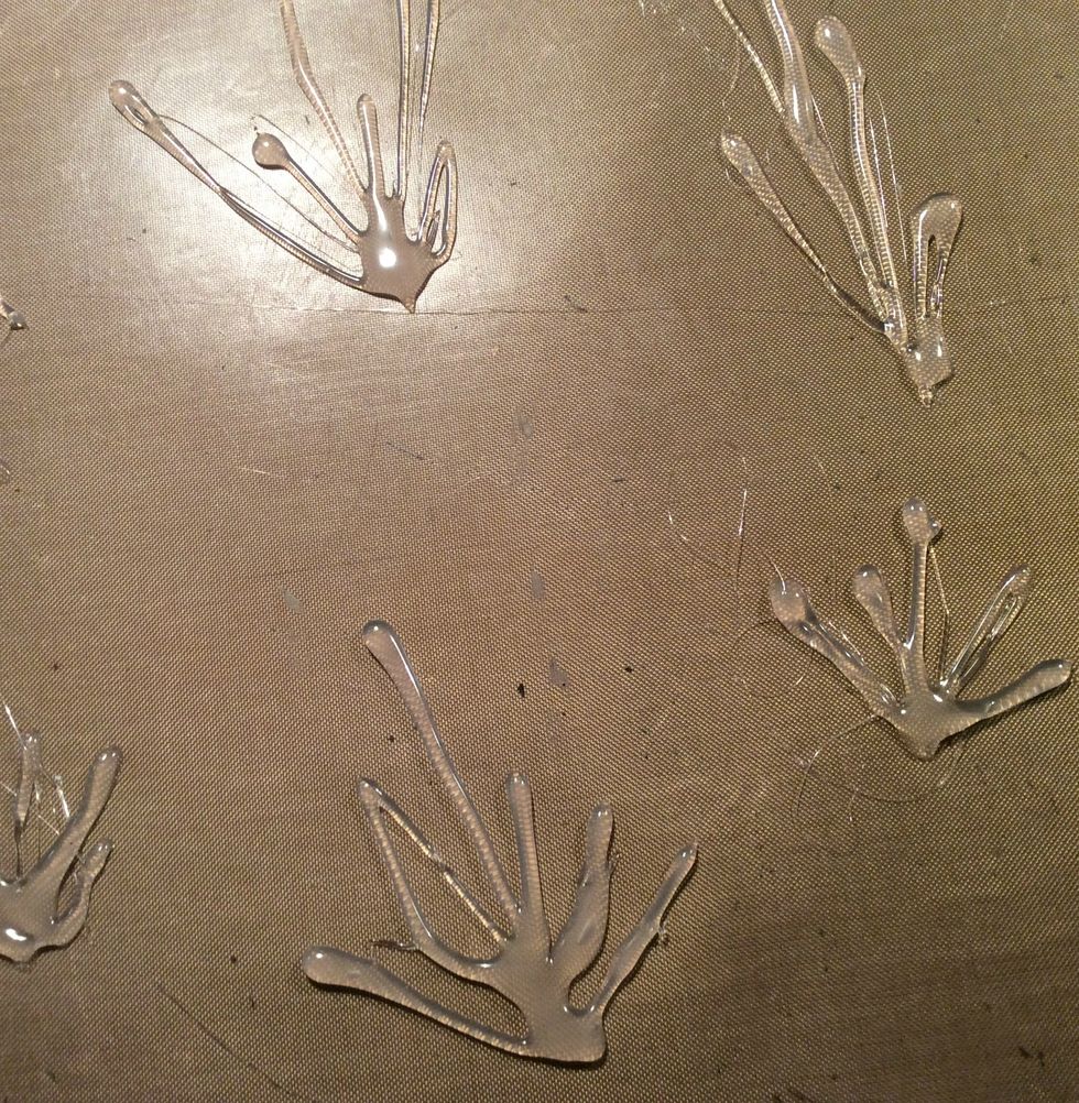 Now the fun part. Using your glue gun on your craft mat, start making random grass shapes. Allow to dry completely.