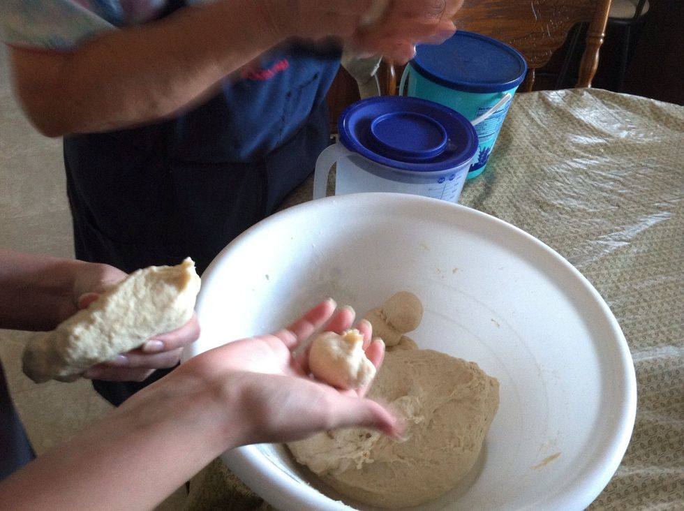 Now the fun part! You want to get a grapefruit size piece of dough, knead it a little in your hands, and make small (golf ball size) dough balls.