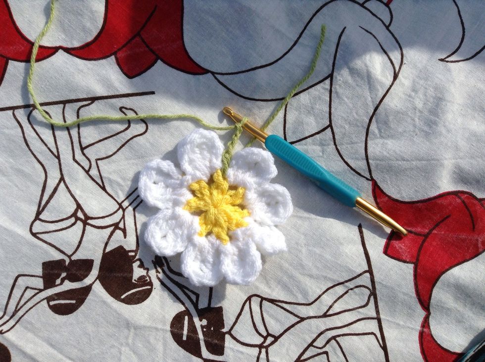 Now the leaves. Join green yarn with a sl st into any of the ch spaces between the petals. Chain 1, 1 sc in same sp, ch 4, *1 sc in next sp, ch 4*, repeat all the way around. Sl st to top of 1st sc.