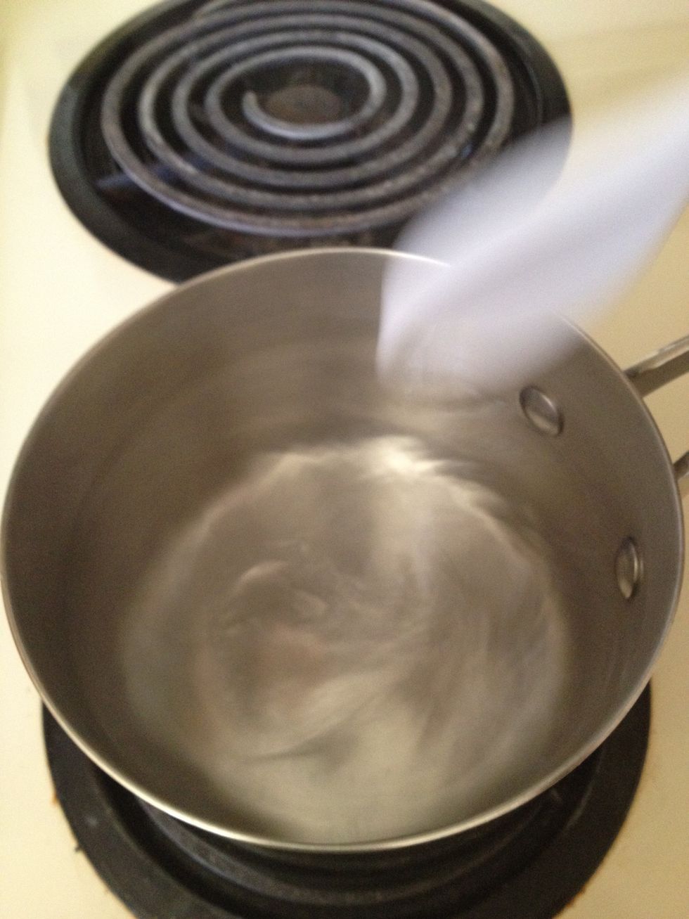 Now, this is an important step for a perfect poached egg. Stir the water in a circular motion to create a whirlpool (for lack of better word) for your egg.